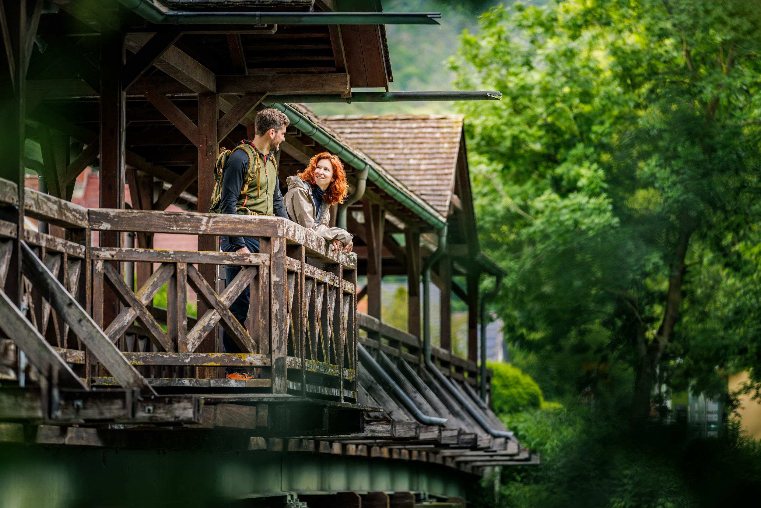 A couple on a bulge of a wooden bridge that crosses the Leitha river