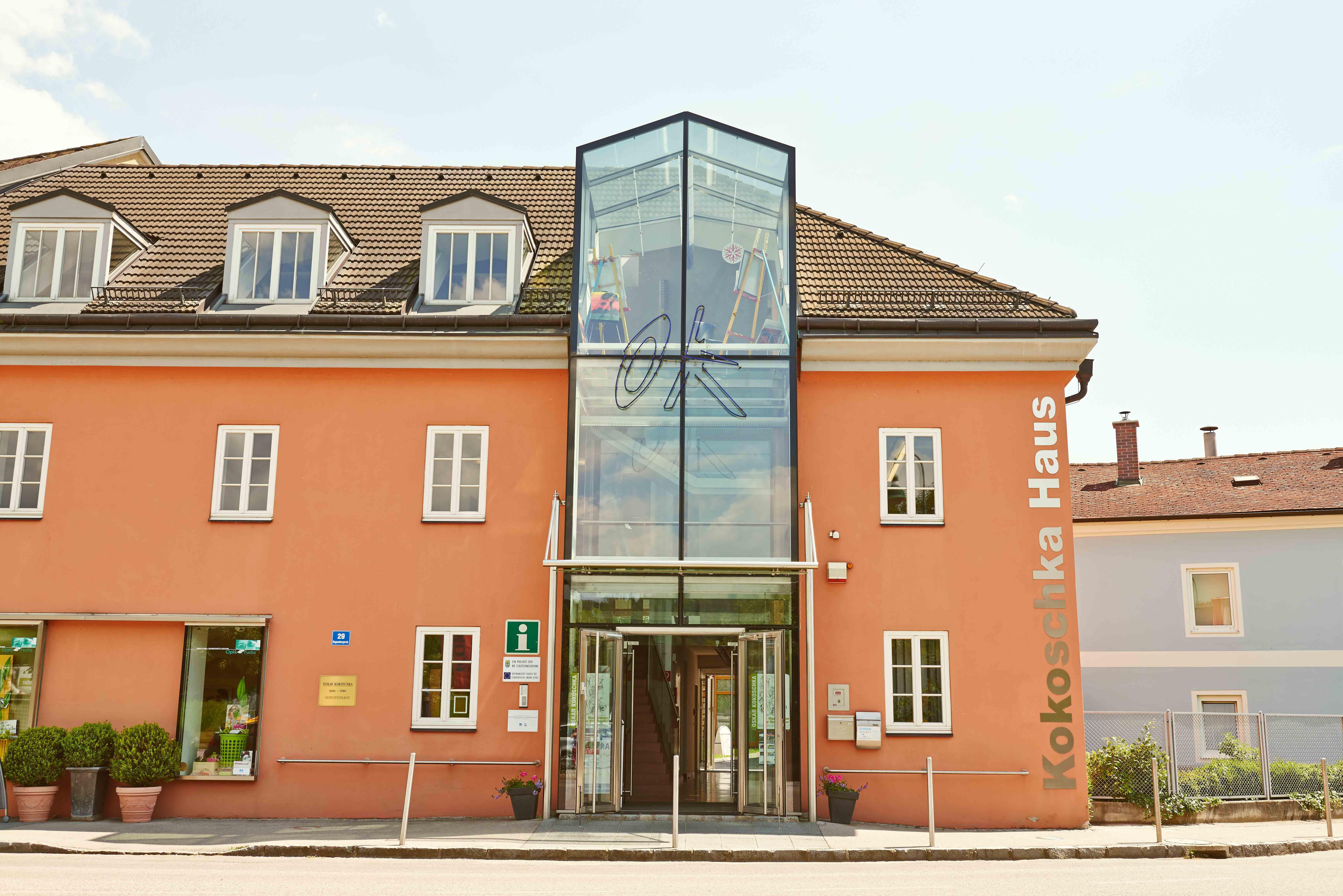 The Oskar Kokoschka House with its orange façade and glass entrance.
