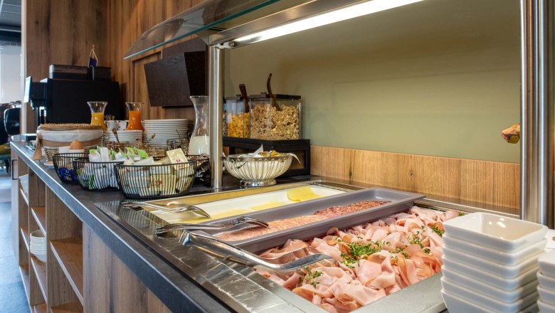 Breakfast buffet with cold cuts, cheese, muesli and drinks.