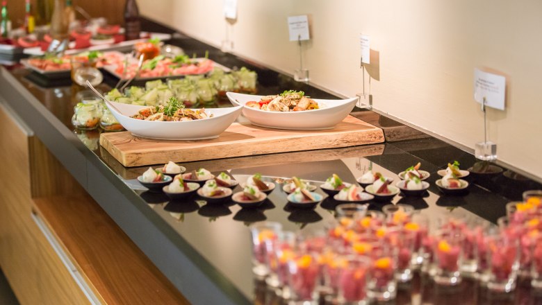 A buffet with various dishes on a table.