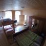 Wood-paneled bedroom with bunk bed, double bed, closet and TV.