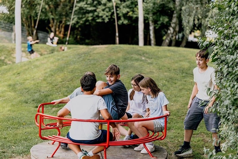 Children playing on an outdoor carousel.