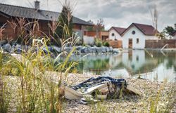 Aerial view of chalets on the garden lake with jetty and deckchair.