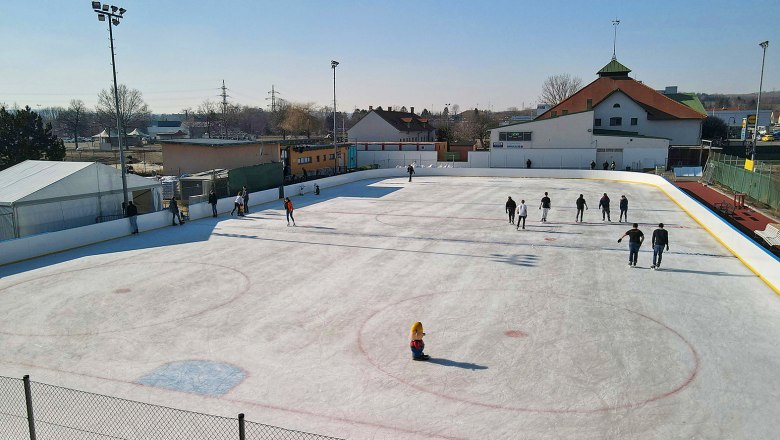 Ice rink with people in Hollabrunn in sunny weather.