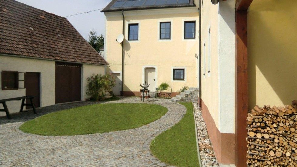 A well-kept courtyard with a paved path, lawn and yellow buildings.