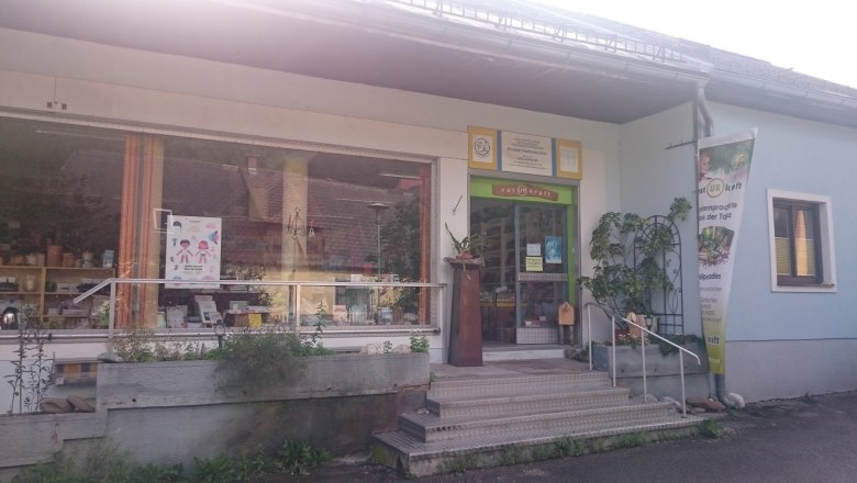 Entrance of a store with shop window and plants.