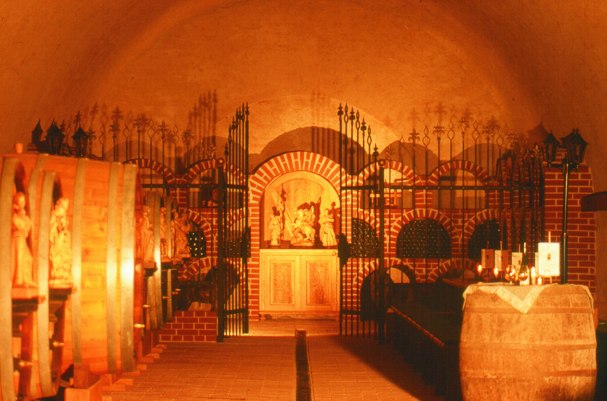 A wine cellar with wooden barrels and decorative grilles.