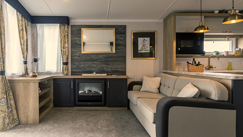 Living space, © Leopold Pluschkowitz Cozy living room with sofa, fireplace, mirror and kitchen.