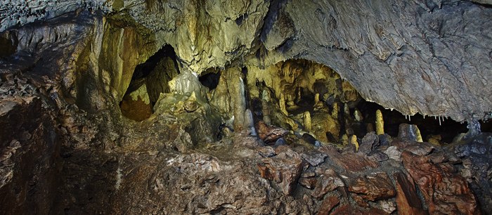 Interior view of a cave with stalagmites and stalactites.