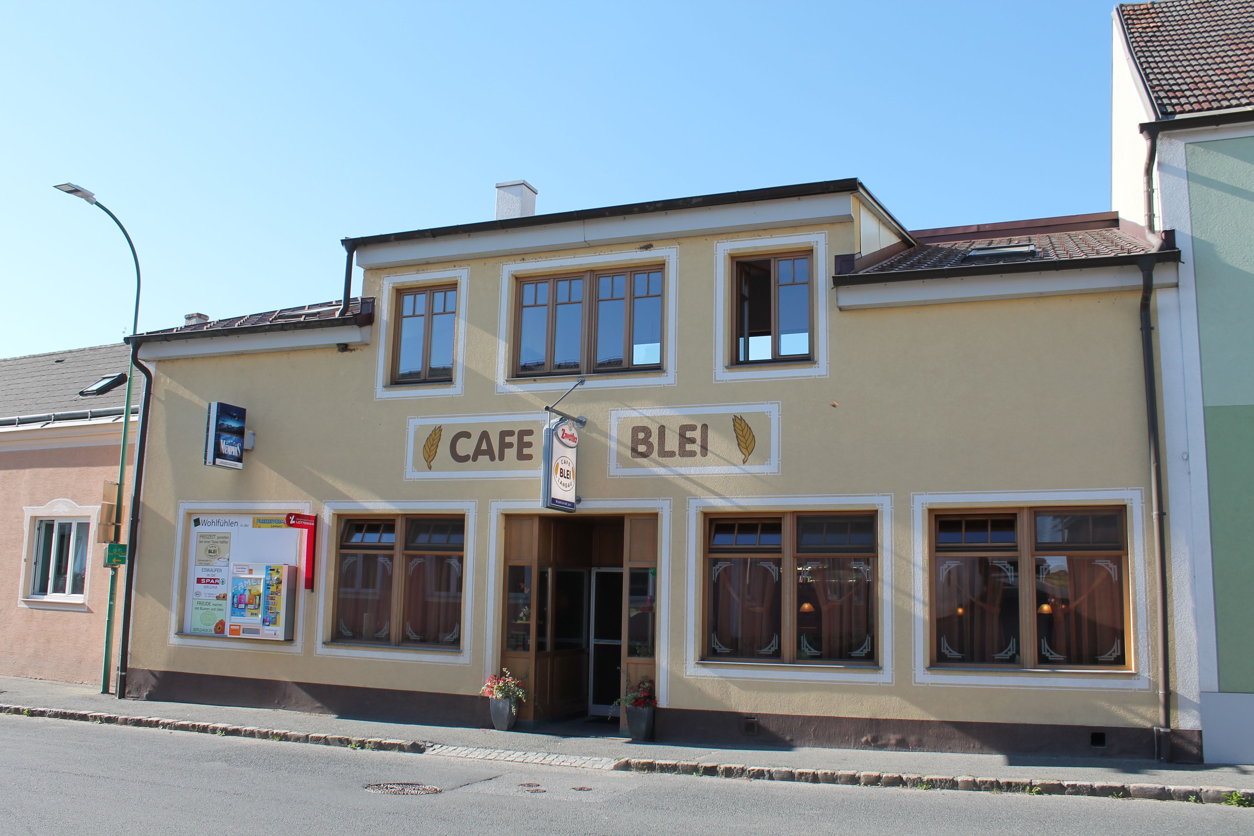 Exterior view of Café Blei with yellow façade and large windows.