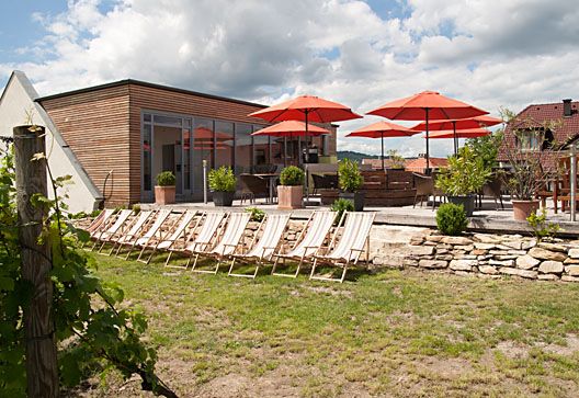 Terrace with sun loungers and red parasols in the garden.