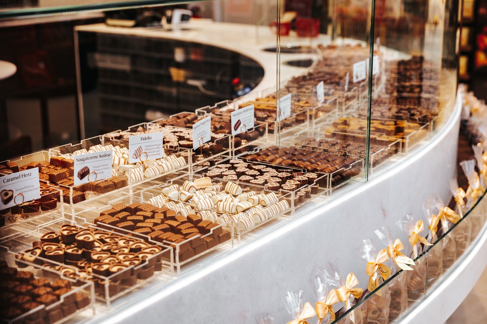 A counter with a large selection of chocolates in different varieties and shapes.