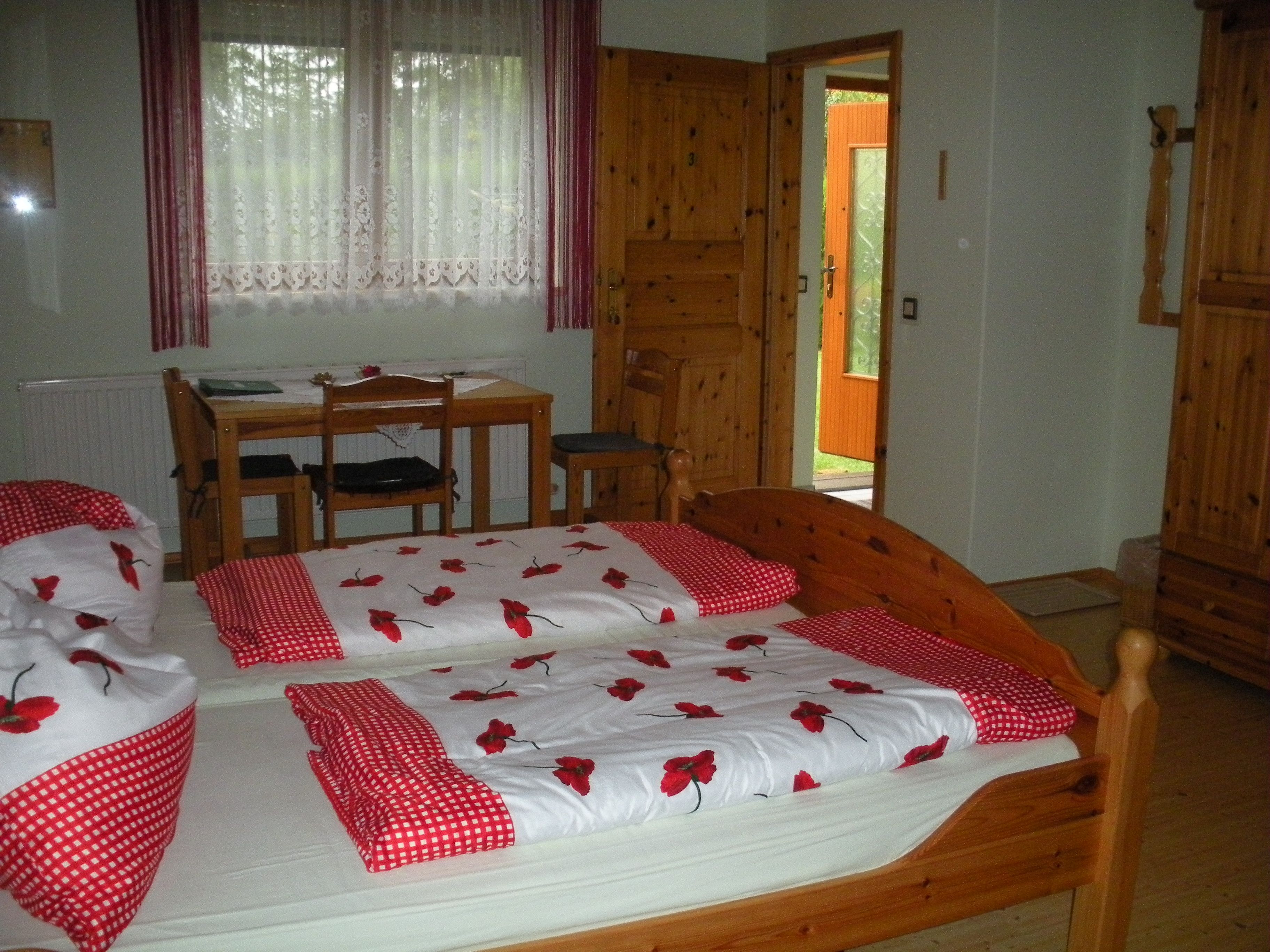 Cozy guest room with wooden furniture, double bed and desk.