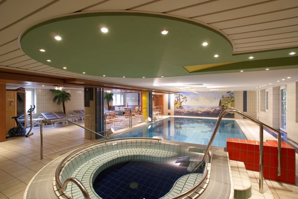 Indoor pool area with whirlpool and sun loungers at Hotel Thier.