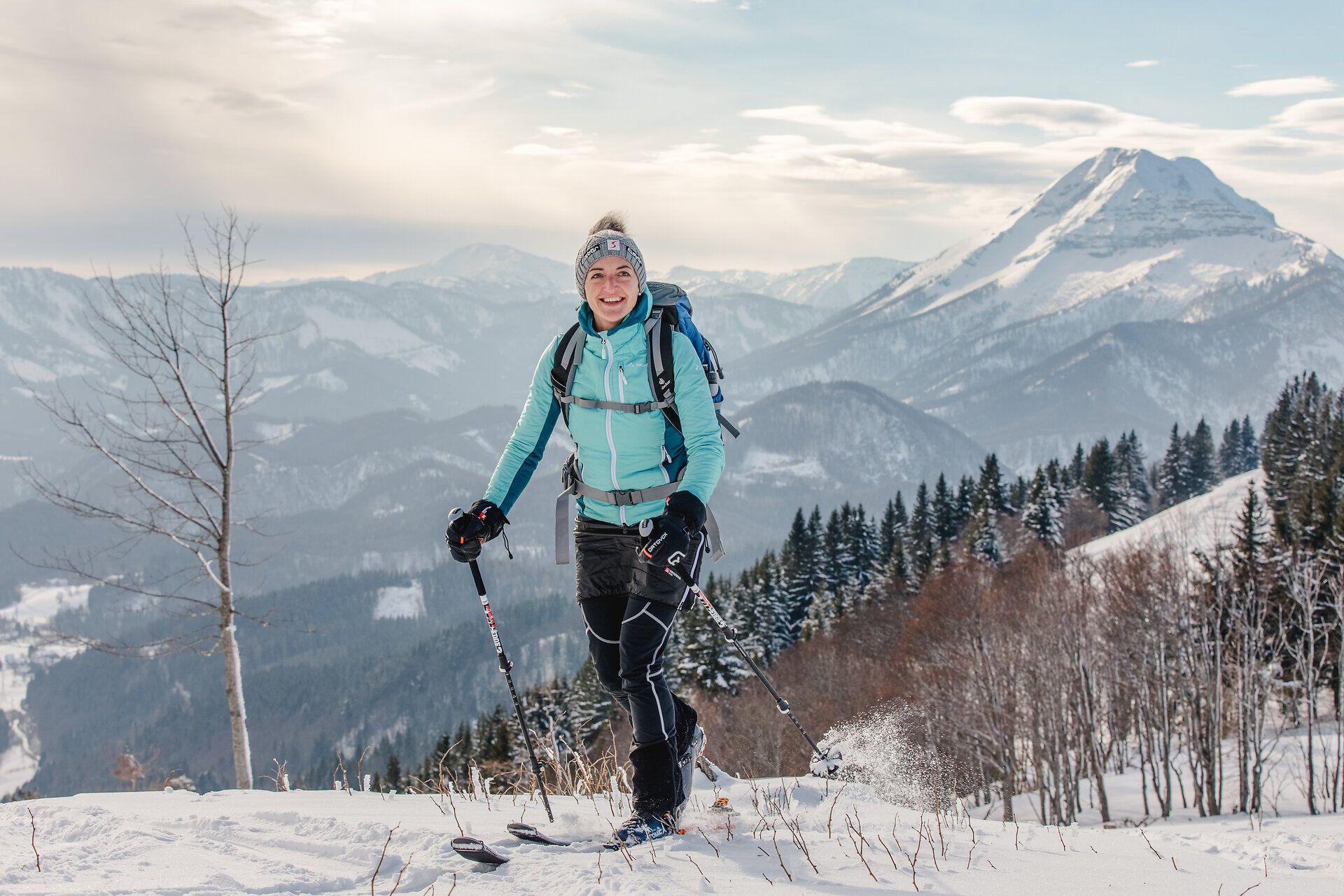 In der winterlichen Berglandschaft von Annaberg strahlt die Sonne über schneebedeckte Gipfel und verzaubert die Umgebung. Ein fröhlicher Skitourengeher genießt die frische, klare Luft und die atemberaubenden Ausblicke auf die majestätischen Berge. Die unberührte Natur lädt dazu ein, die Ruhe und Schönheit der winterlichen Alpen zu erleben.