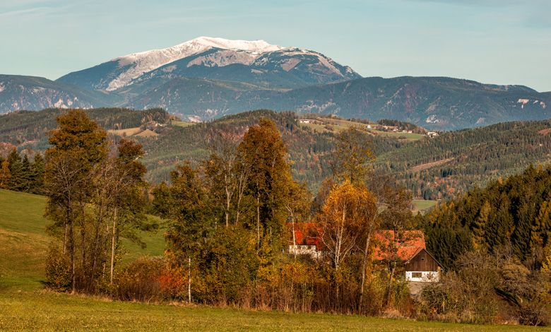 Landscape with mountains, trees and a house in the fall.