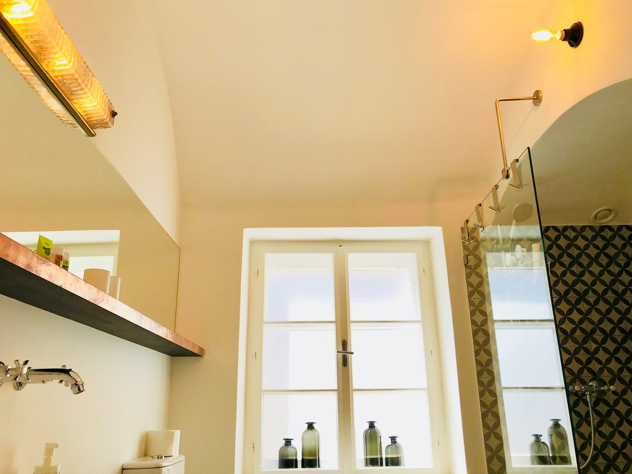 Modern bathroom with glass shower and decorative tiles.
