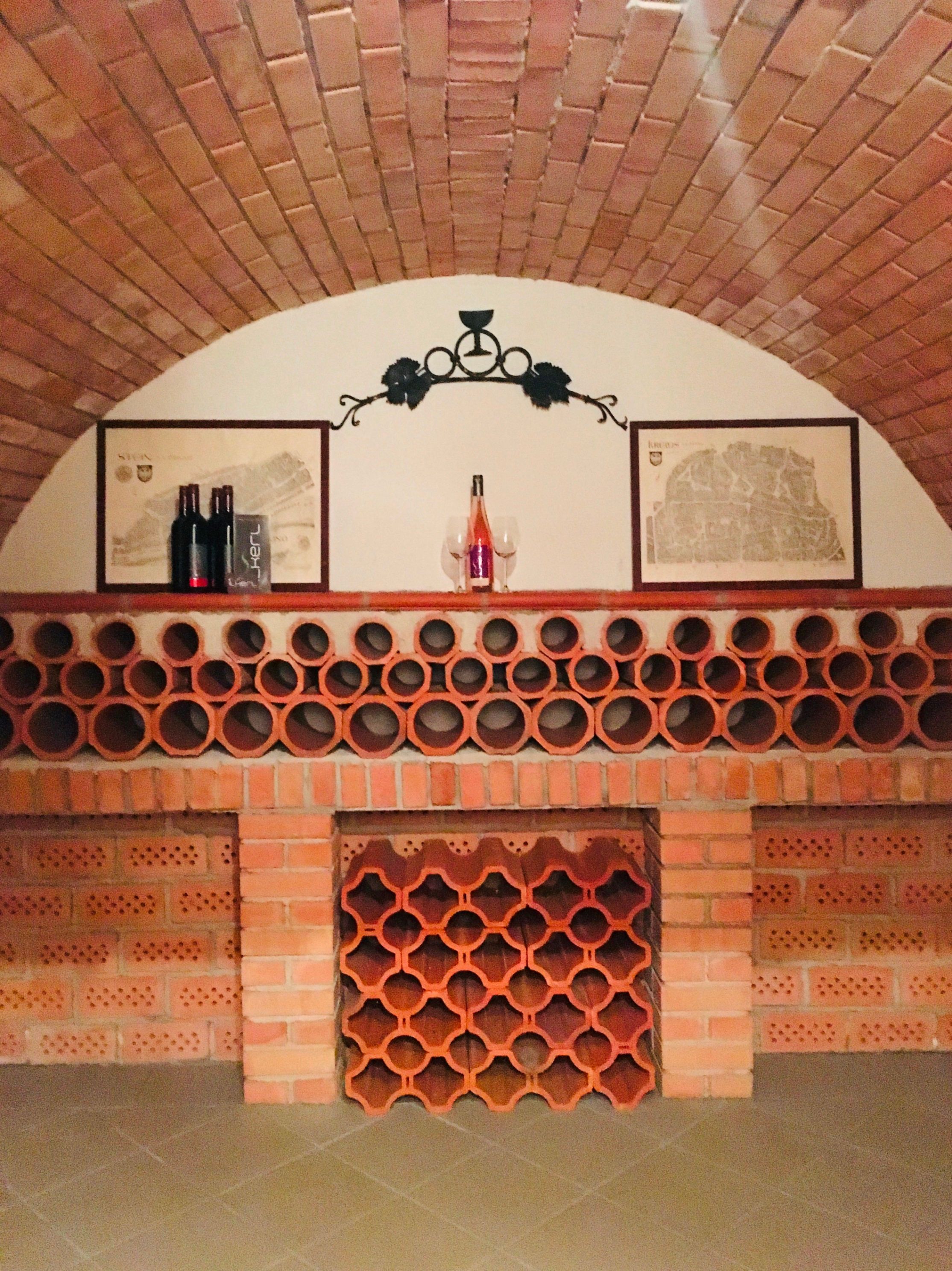 Wine cellar with brick ceiling and terracotta wine racks.