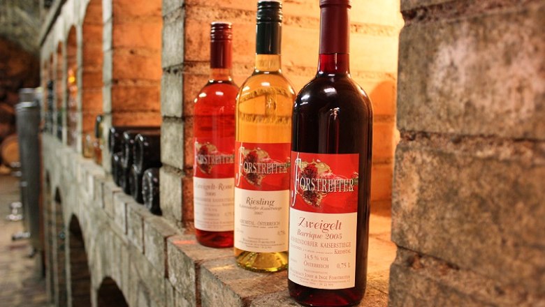 Three bottles of wine on a shelf in the wine cellar.