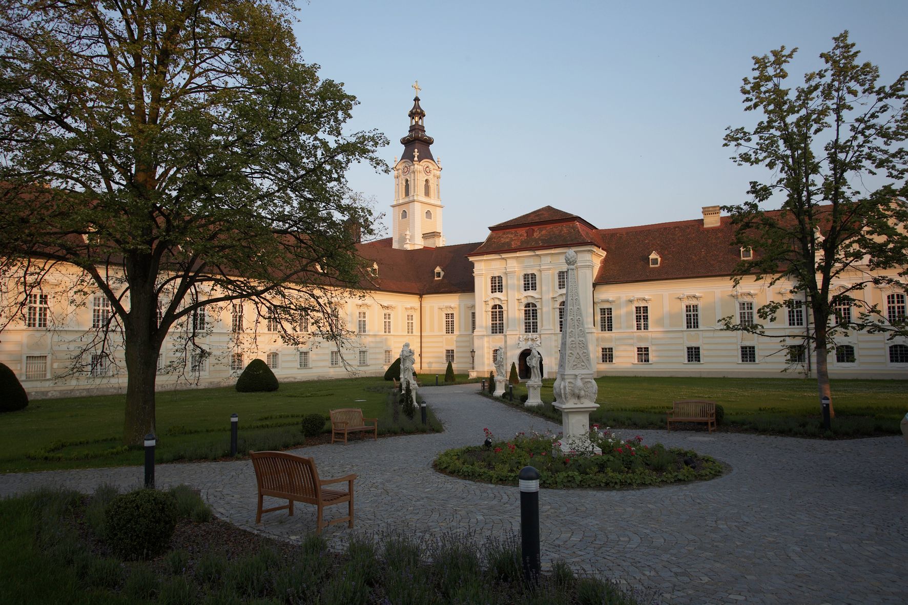 Altenburg Abbey with garden and sculptures in the foreground.