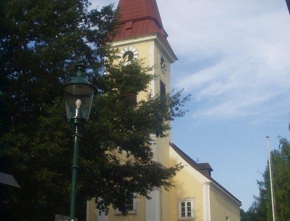 Exterior view of Sulz parish church with tower and clock.
