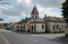 Street in Lanzendorf with church and residential buildings.