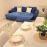 Living room with blue sofa and dining table with place settings.