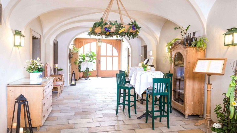 Entrance area of the Loibnerhof with wooden furniture and plants.