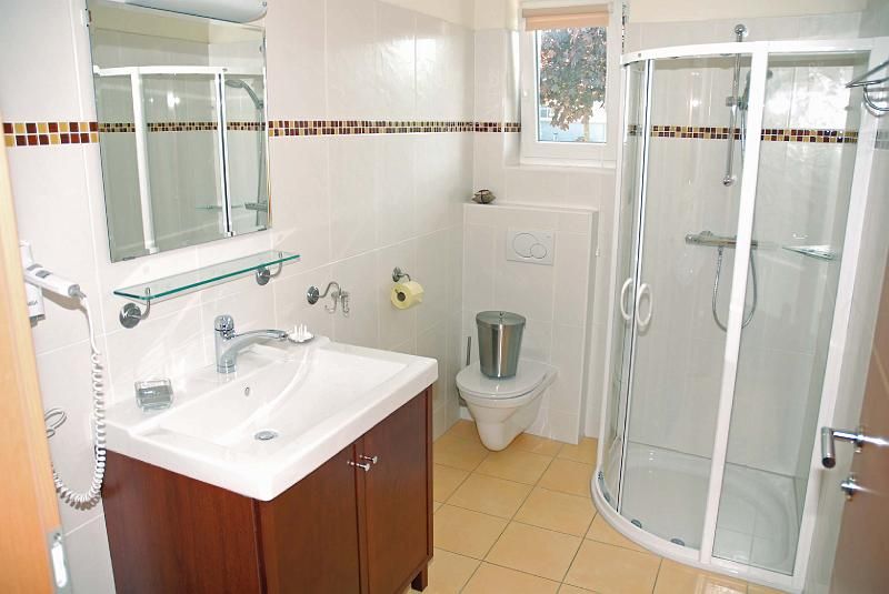 Modern bathroom with shower, washbasin and toilet.