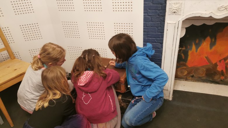 4 Kinder sitzen am Boden und lösen ein Rätsel