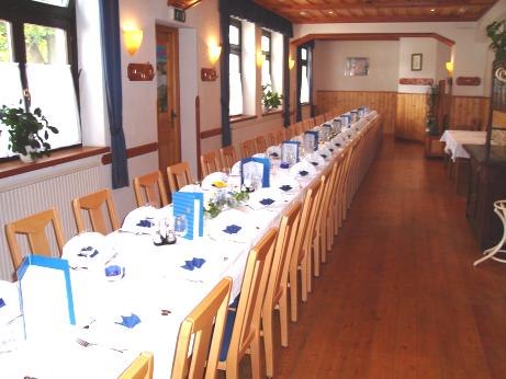 A long, festively laid table in a hall with a wooden floor and ceiling.