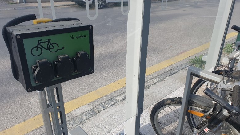 E-bike charging stations with sockets and bicycles next to it.
