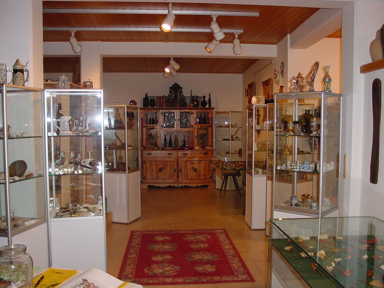 Interior view of a museum with glass showcases full of pipes and collector's items.