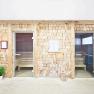 Two sauna cabins with wooden walls and glass doors in a wellness area.