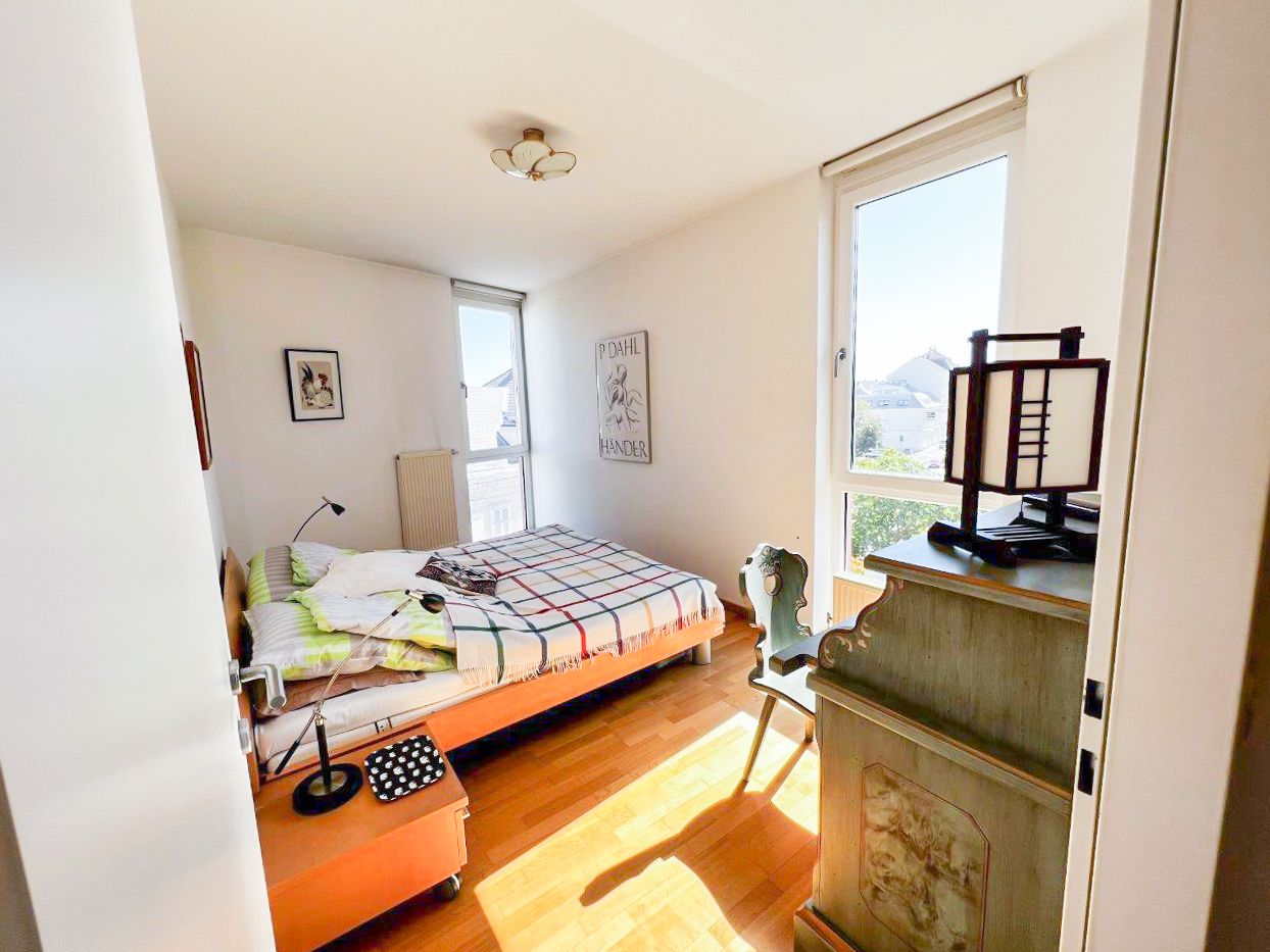 Bright bedroom with bed, desk and window.