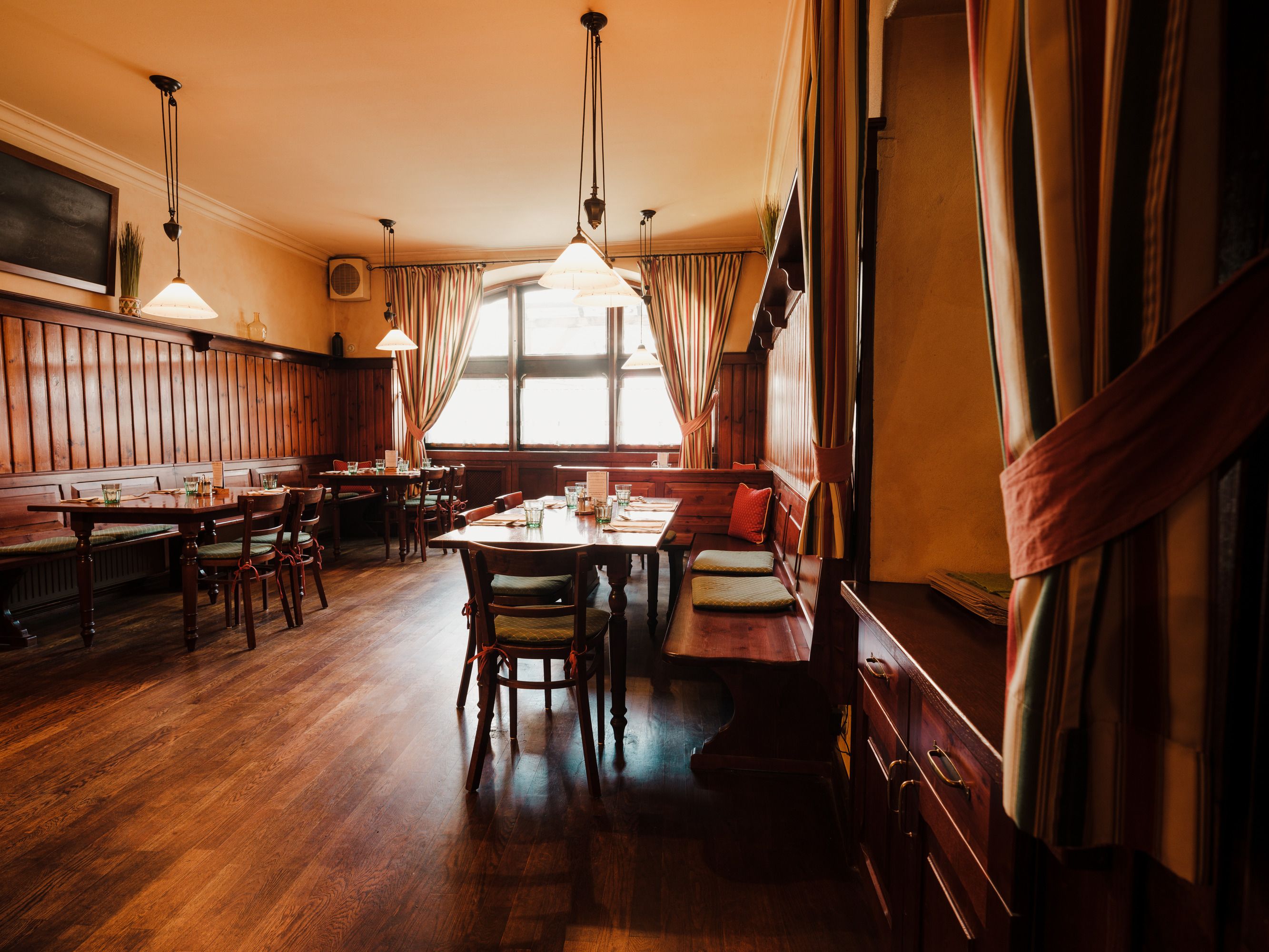 Cozy restaurant with wooden furniture and warm light.