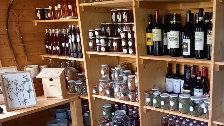 Shelves with bottles, glasses and wine in a wooden store.
