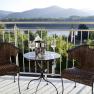 Two rattan chairs and a table with a champagne cooler on a terrace with a mountain view.