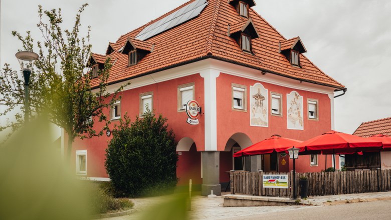A red building with red sunshades and solar panels on the roof.