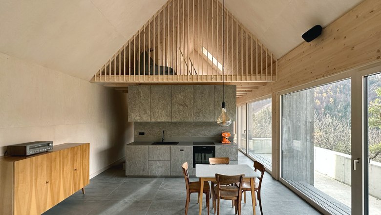 Modern open kitchen with wooden elements and large windows.