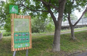 Bicycle starting point board in Lanzenkirchen with map and information, surrounded by trees.