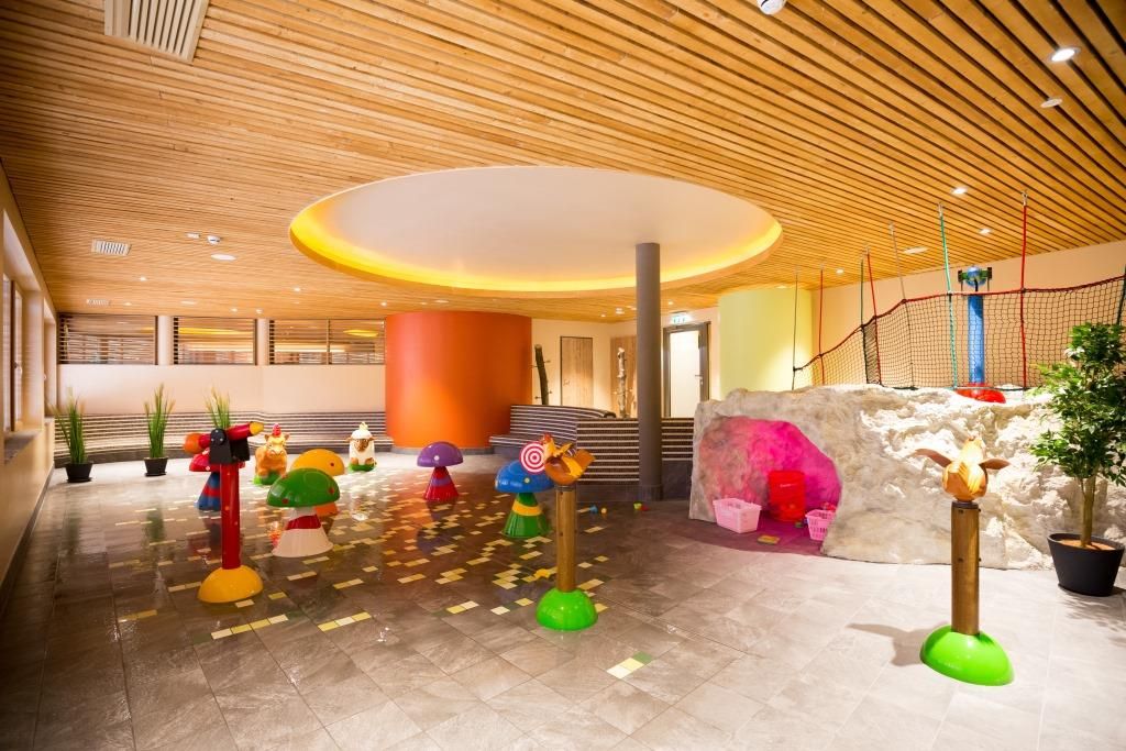 Indoor area of the JUFA Hotel Annaberg with colorful water games and climbing area.