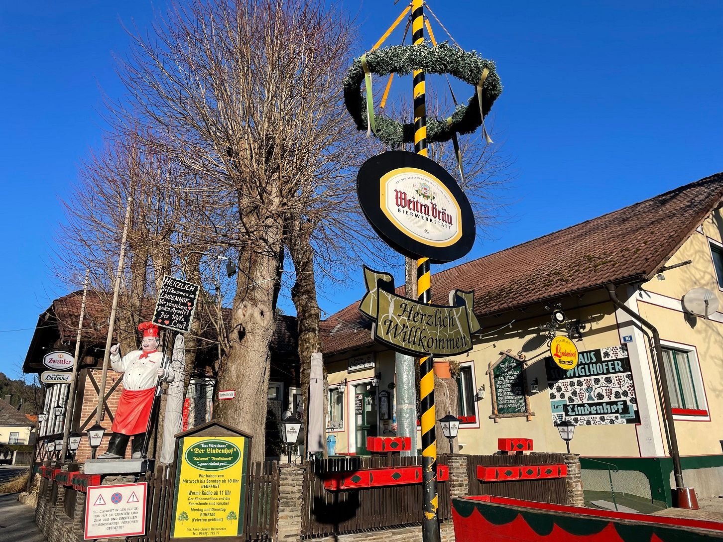 Gasthaus Lindenhof in Pernitz with maypole and signs.
