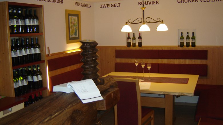 Interior view of a winery with table, chairs and wine racks.
