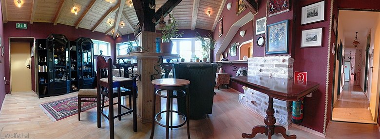 Cozy club room with wooden furniture, carpet and pictures on the walls.