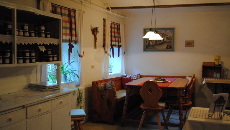 Cozy kitchen with wooden furniture and checkered curtains.