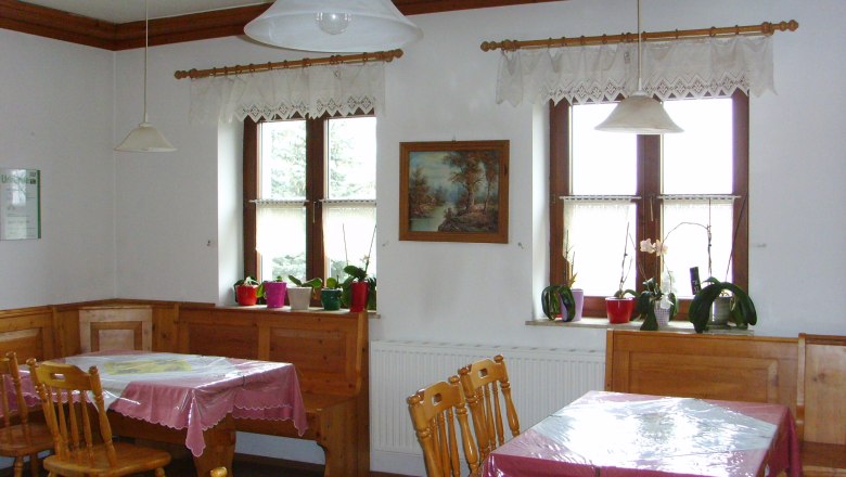 Cozy room with wooden furniture, tablecloths and plants on the windowsill.