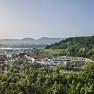 View of the Steigenberger Hotel & Spa Krems surrounded by vineyards and hills.