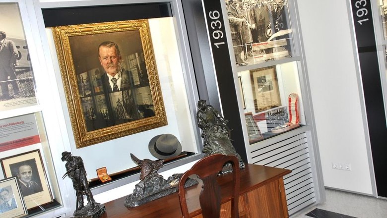 Interior view of a museum with paintings, sculptures and historical photos.