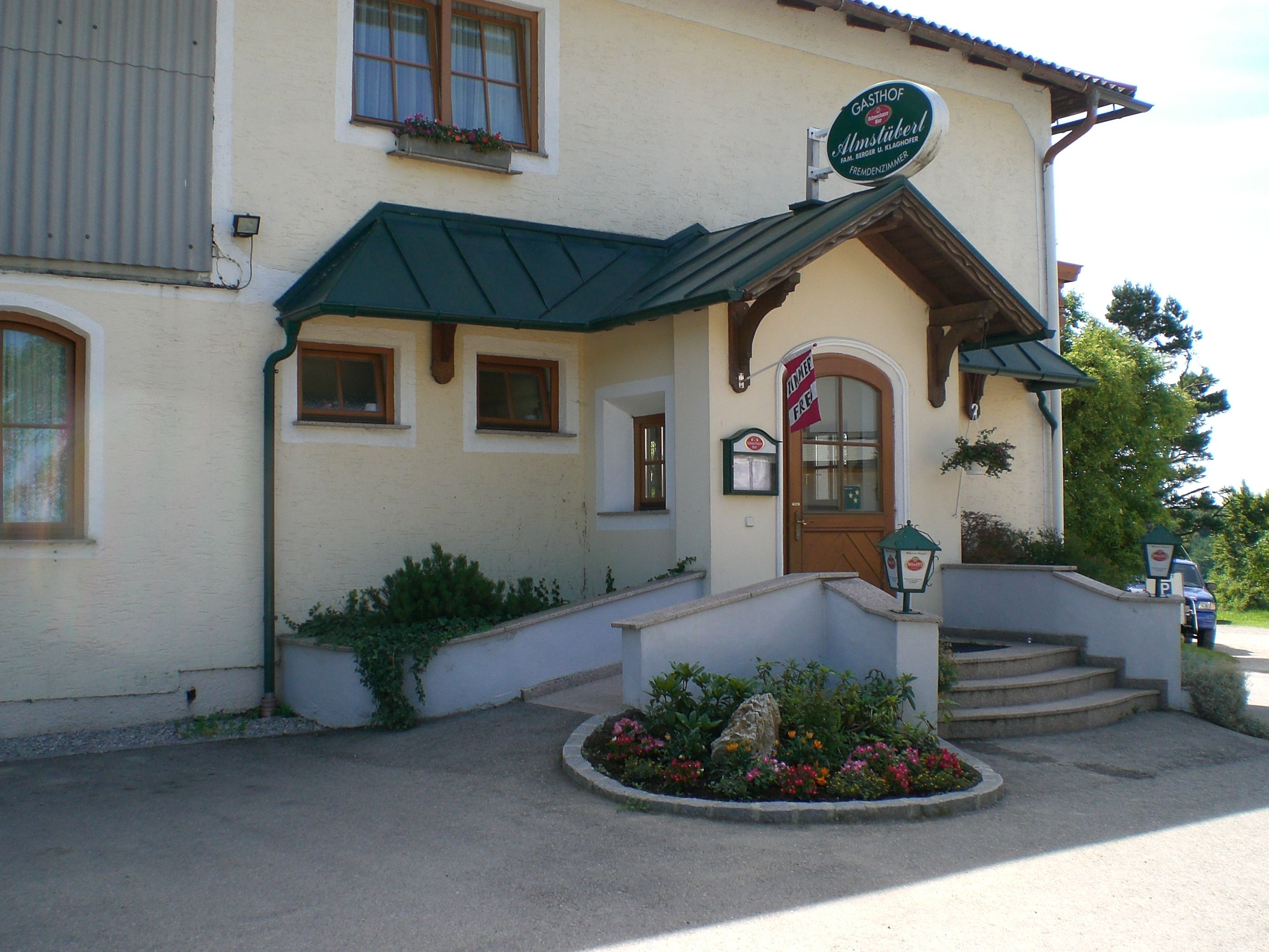 Entrance to a bed and breakfast with sign 'Almstüberl'.